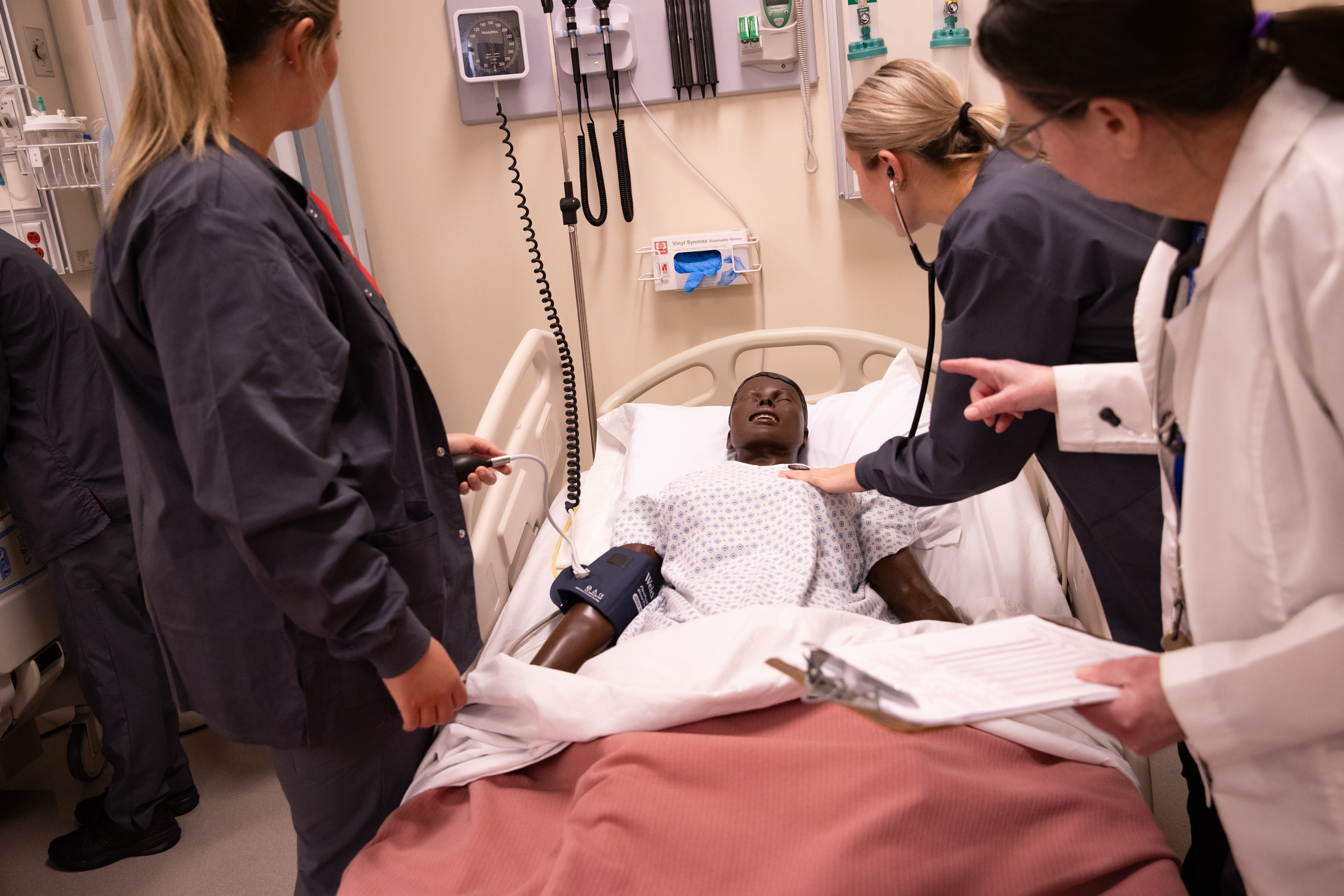 Nursing students practicing on a mannequin 