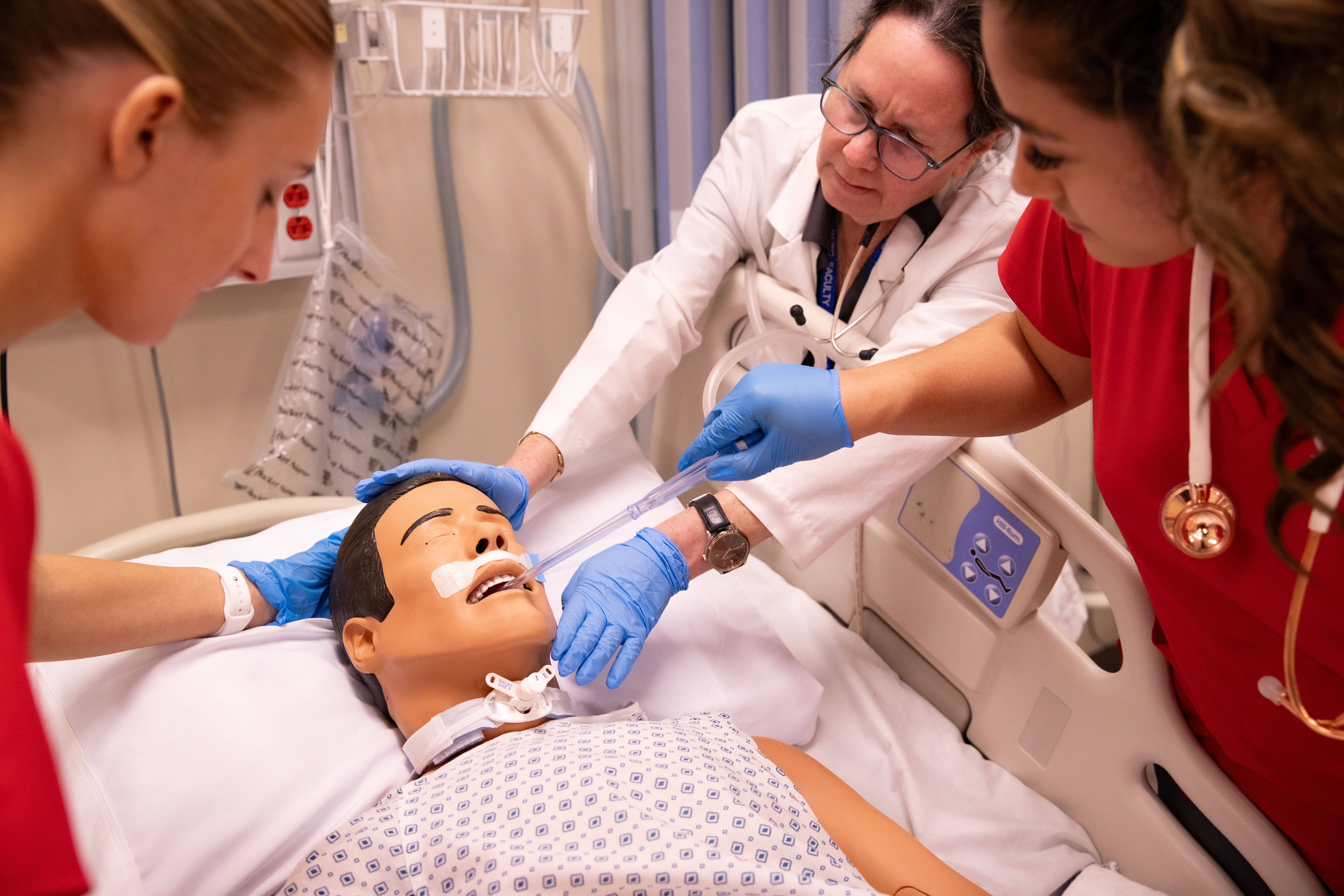 Nursing students practicing on a mannequin