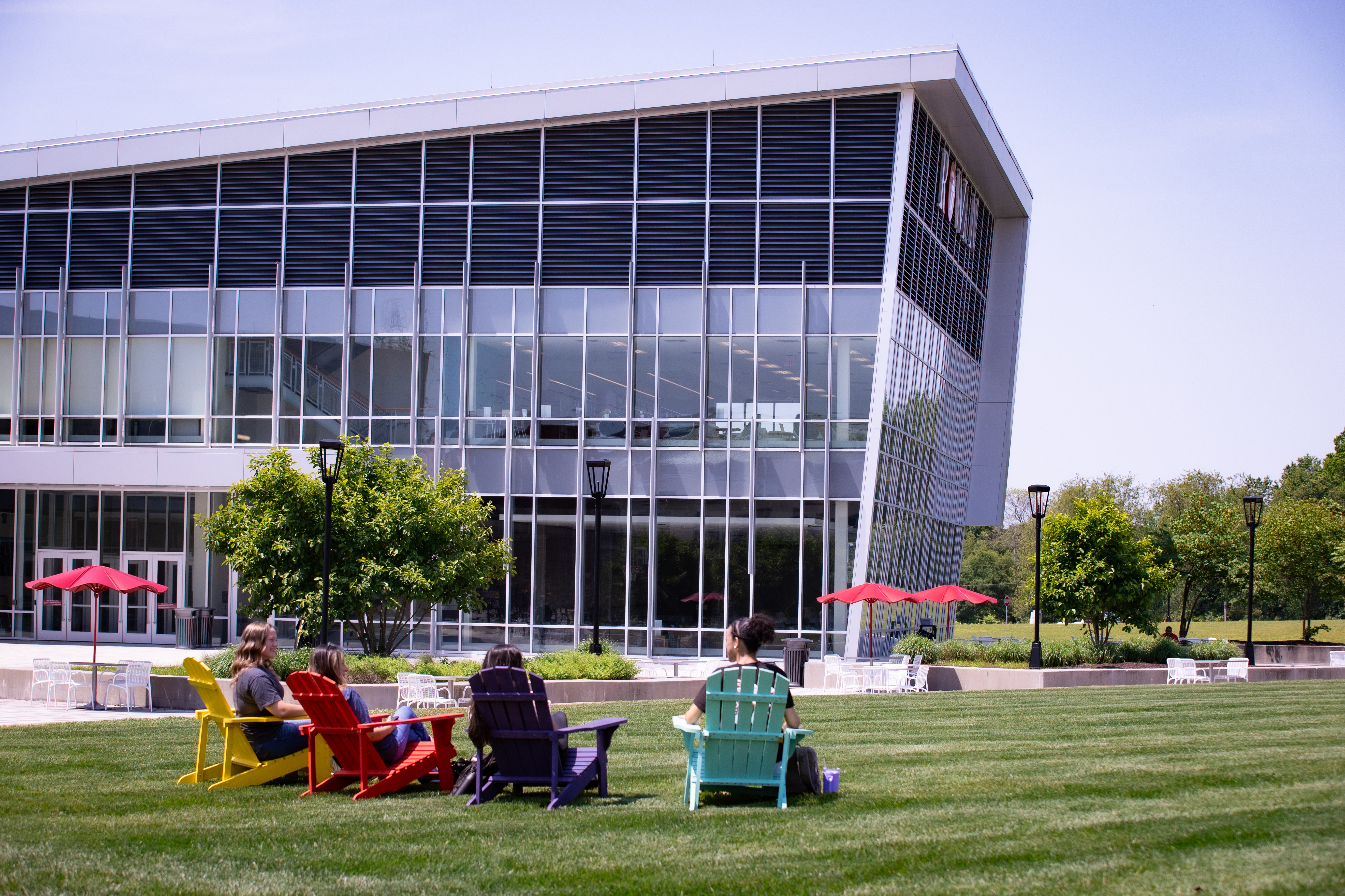 RCBC students sitting in Adirondack chairs on the quad