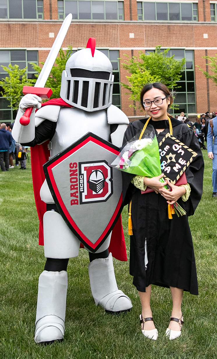Barry standing with a female asian student at graduation