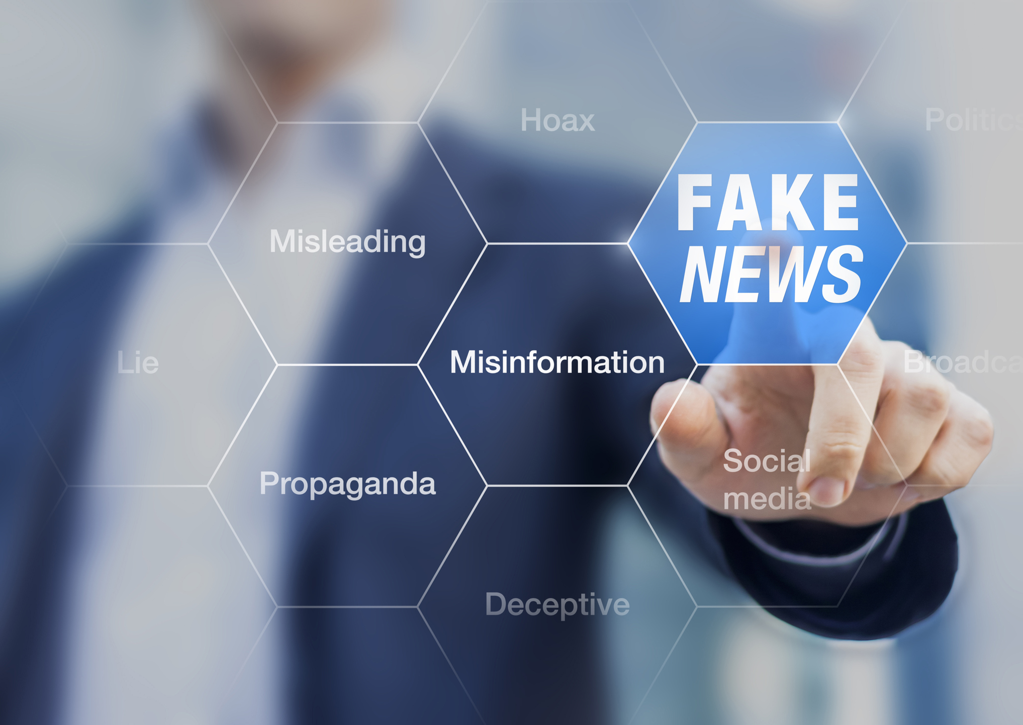 man pointing to various words including "fake news, misinformation, misleading"