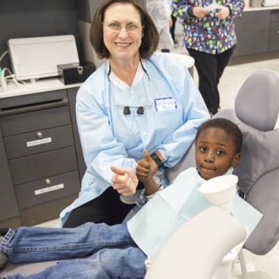 dentist with kid in dentist chair 