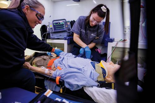 Two RCBC paramedic students practicing on a manikins inside an ambulance simulator in the Health Sciences Center.