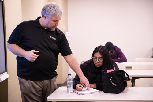 Adult Basic Education instructor helping a student with her notes