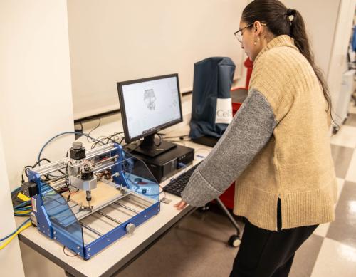 Mechanical engineering student using a CNC machine