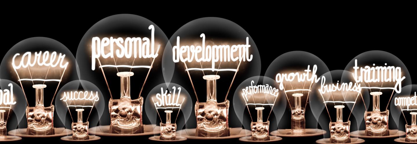 lightbulbs with personal and professional development key words lit up inside them 