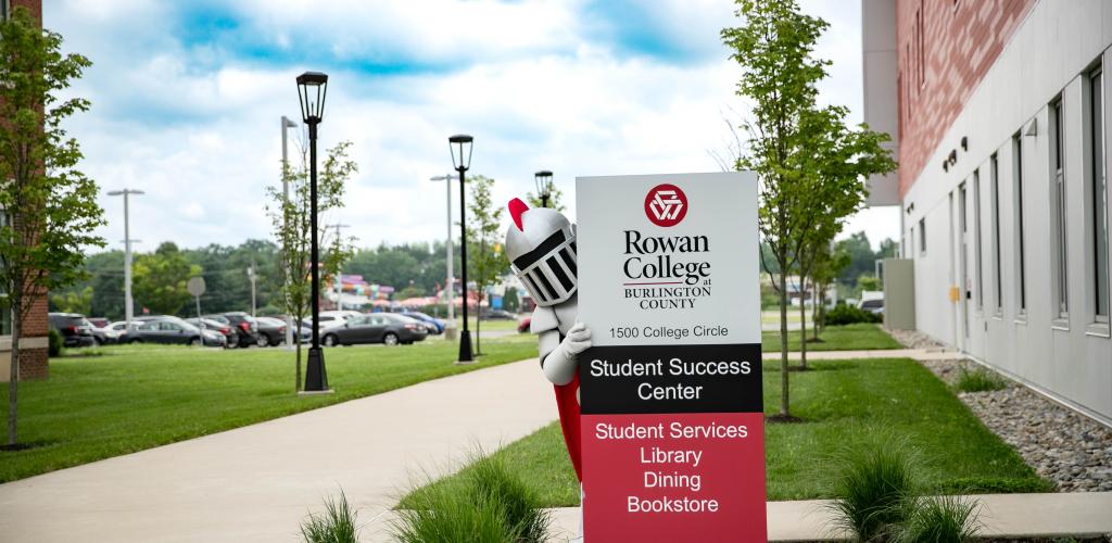 Barry peaking out behind the Student Success Center entrance sign