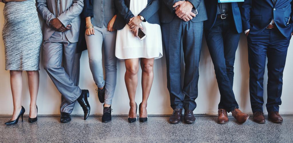 Group of business people standing against the wall 