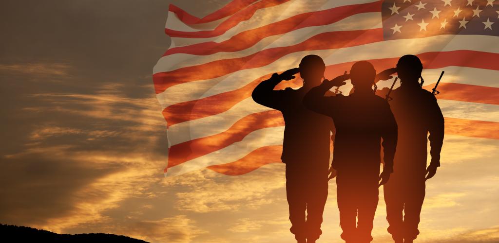 Three soldiers saluting with American Flag in the background