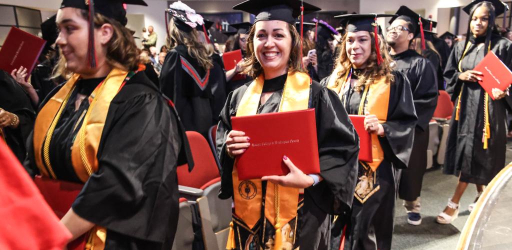An RCBC graduate smiles with her diploma.