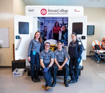 RCBC paramedic students posing in and outside an ambulance simulator in the Health Sciences Center.