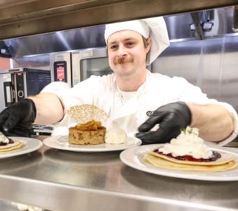 RCBC culinary student placing desert dishes on serving rack