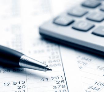 pen and calculator on top of spreadsheet