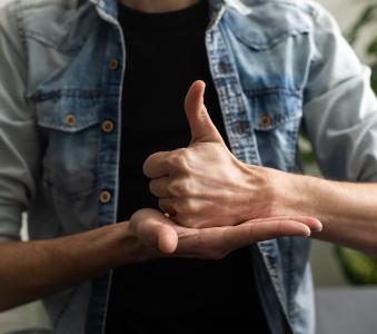 Sign language interpreter man translating a meeting to ASL, American Sign Language.