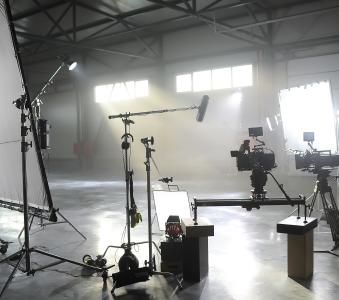 Profesional video studio.Behind-the-scenes of a video shooting.Behind the shooting production silhouette of camera and equipment in studio.