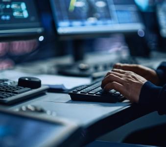 Close Up of a Professional Office Specialist Working on Desktop Computer in Modern Technological Monitoring Control Room with Digital Screens. Manager Typing on keyboard and Using Mouse.