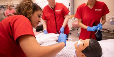 Three RCBC Health Sciences students practicing on a dummy