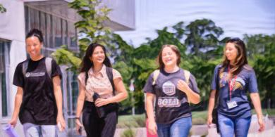 Four RCBC students walking outside and smiling (photo has crayon filter applied to it)