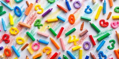 crayons and colorful plastic numbers on a white table