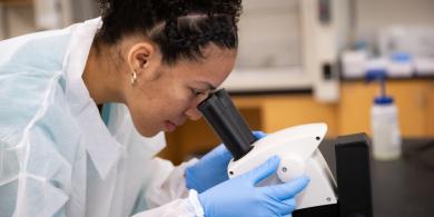 RCBC Biology student looking through a microscope
