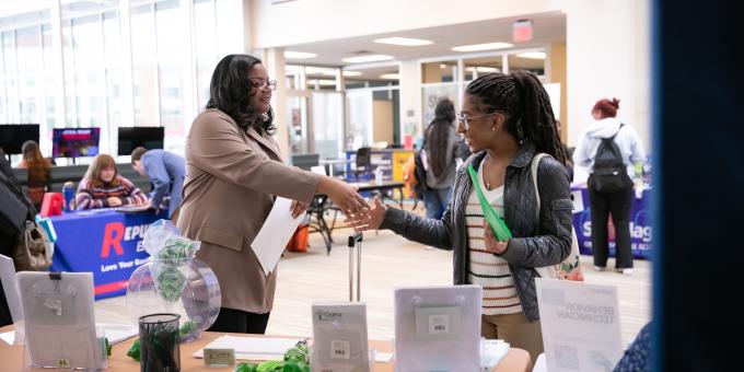 Employer shaking student hand at career fair