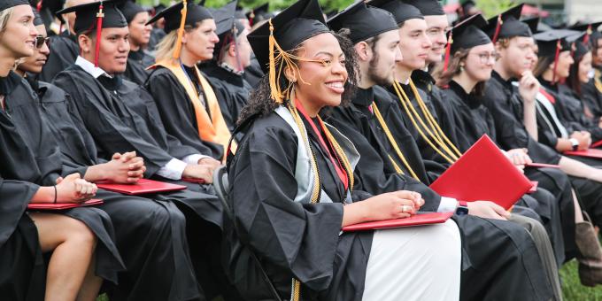 RCBC students sitting down outside on the quad during commencement