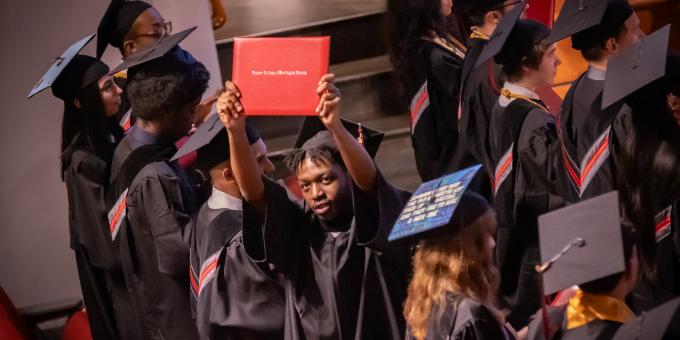 RCBC graduate holding up his diploma 