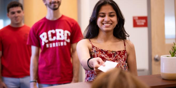 Students line up at the welcome desk of the test center.