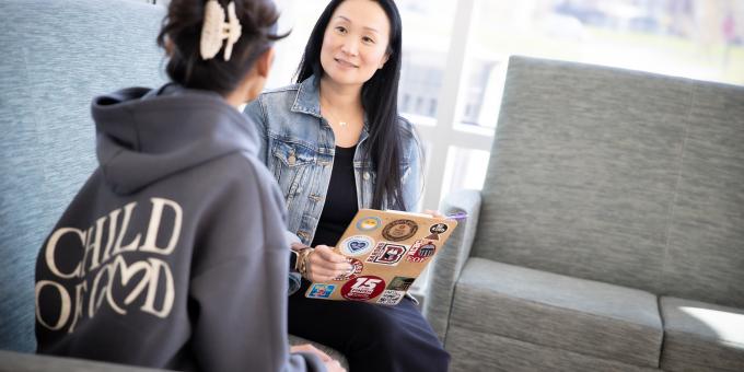 Mimi Oliveira sits with a student at the Student Success Center.