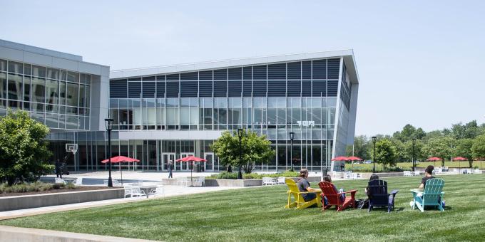 Four RCBC students sit on the quad outside the SSC on BOLD colored chairs