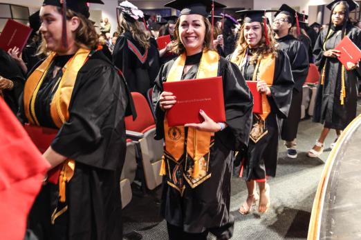 An RCBC graduate smiles with her diploma.