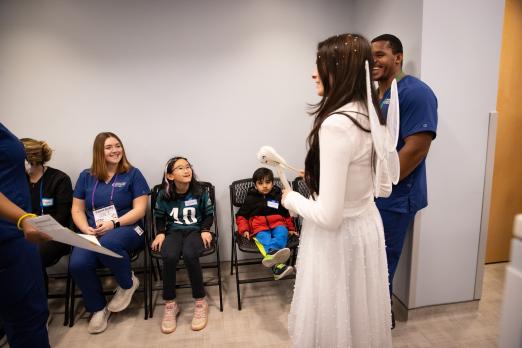 The tooth fairy visiting students and dental staff members in the waiting room