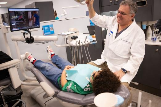 A child receiving dental work from a smiling dentist