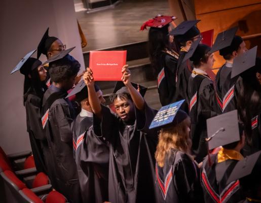 RCBC graduate holding up his diploma 