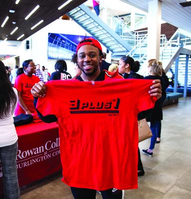 A student smiles with a 3+1 t-shirt on 3+1 day in the SSC.