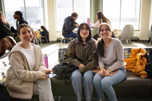 RCBC Students sitting on a couch and smiling inside Laurel Hall loung