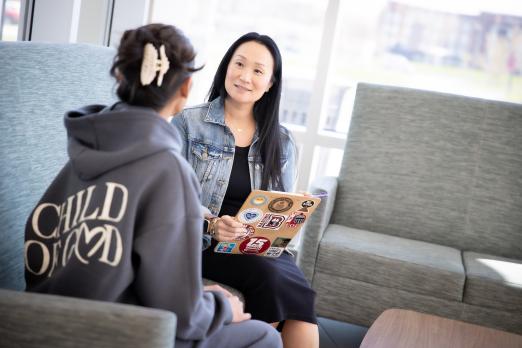 Mimi Oliveira sits with a student at the Student Success Center.