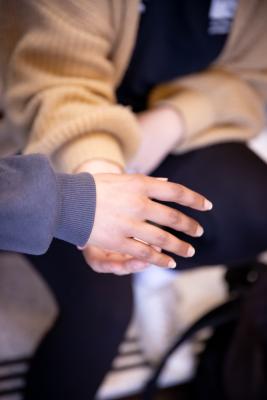 Students putting their hands in the middle of a circle