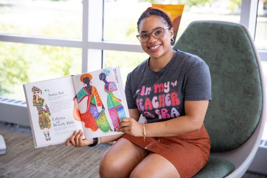 RCBC Education student smiling while holding an open book