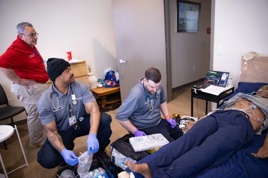RCBC EMT students participating in a simulation with an instructor looking on.