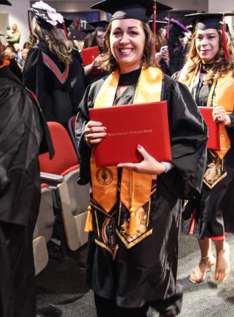 An RCBC graduate smiles with her diploma.