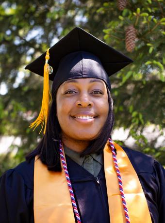 President's Award winner Ariel Howard poses outside in her graduation regalia.