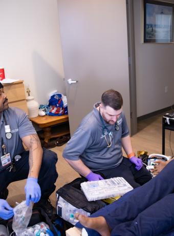 RCBC EMT students participating in a simulation with an instructor looking on.