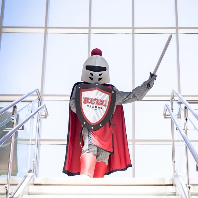 Barry at the top of the stairs pointing his sword towards the ceiling