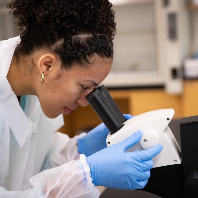 RCBC Biology student looking through a microscope